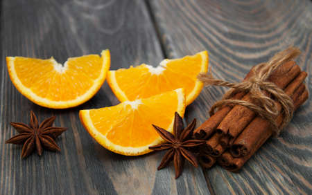 Orange with cinnamon sticks on a wooden backgroundの写真素材