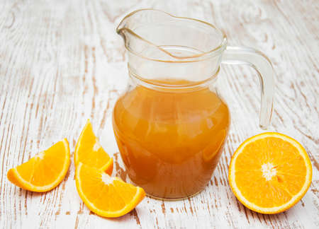 Orange juice in pitcher and fresh orangesの写真素材