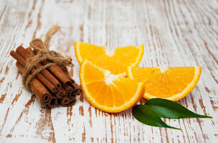 Orange with cinnamon sticks on a wooden backgroundの写真素材