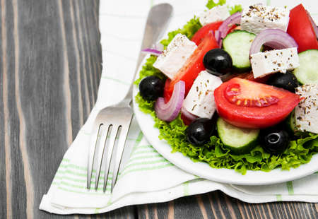 Plate with Fresh Greek salad on a wooden backgroundの写真素材