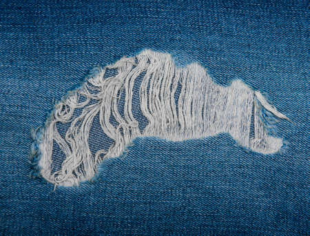 Torn blue denim jeans - detail textureの写真素材