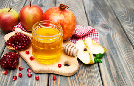 honey apple and pomegranate on wooden tableの写真素材