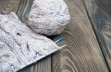 knitting and needles on rustic wooden background