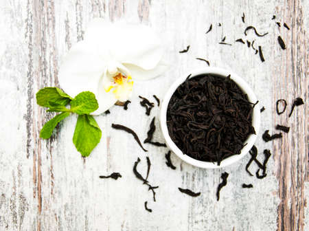 Black  tea with orchid flower on a wooden  backgroundの写真素材