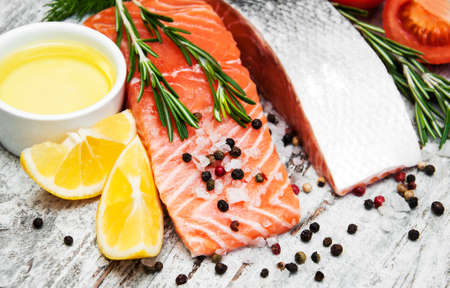 portions of fresh salmon fillet with aromatic herbs, spices and vegetablesの写真素材