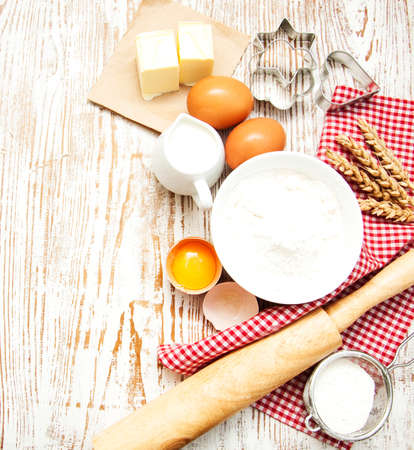 Baking ingredients - eggs, flour, and butter on a wooden backgroundの写真素材