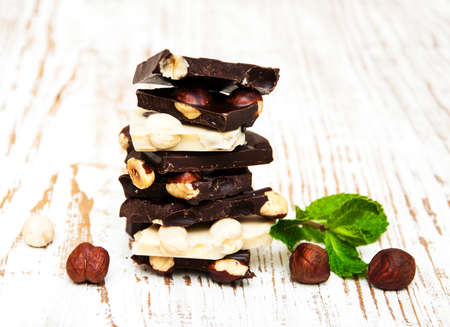 Dark and white chocolate with nuts on a wooden backgroundの写真素材