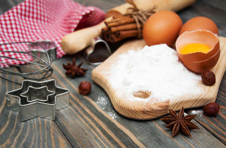 Baking ingredients - eggs, flour, and butter on a wooden background