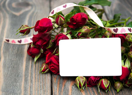 Red roses with greeting card on a wooden   backgroundの写真素材