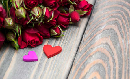 Red roses  and hearts on a wooden backgroundの写真素材