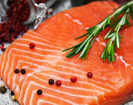 portions of fresh salmon fillet with aromatic herbs, spicesの写真素材