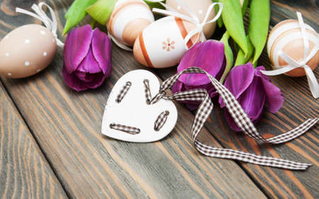 Tulips and easter eggs on a old wooden tableの写真素材