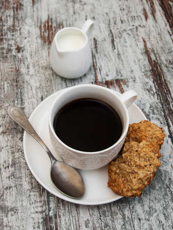 Oatmeal cookies and cup of coffee on a old wooden backgroundの写真素材