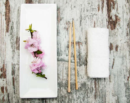 plate, chopsticks, towel  and sakura branch on a bamboo matの写真素材