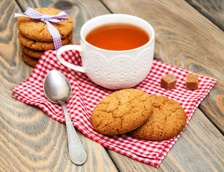 Cup of tea with oatmeal cookies on a wooden backgroundの写真素材