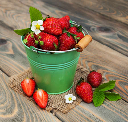 Bucket with strawberries on a wooden backgroundの写真素材