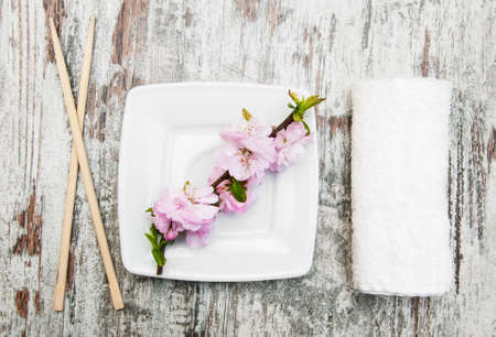 plate, chopsticks, towel  and sakura branch on a wooden backgroundの写真素材