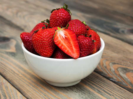 Bowl with strawberries on a old wooden backgroundの写真素材