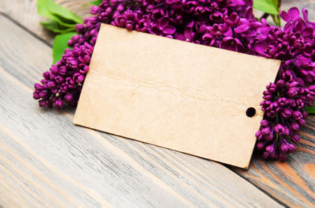 Lilac flowers with empty tag on a old wooden backgroundの写真素材