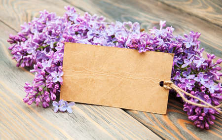 Lilac flowers with empty tag on a old wooden backgroundの写真素材