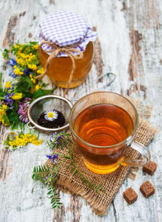 Cup of tea, honey and flowers on a old wooden backgroundの写真素材