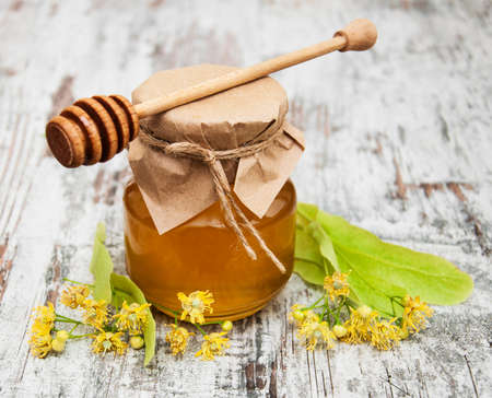 Jar with honey and linden flowers on a wooden backgroundの写真素材