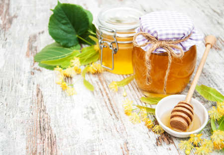Jar with honey and linden flowers on a wooden backgroundの写真素材