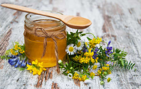 Honey and wild flowers on a old wooden backgroundの写真素材