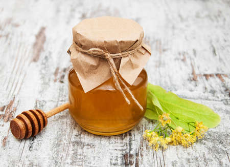 Jar with honey and linden flowers on a wooden backgroundの写真素材