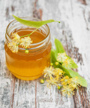 Jar with honey and linden flowers on a wooden backgroundの写真素材