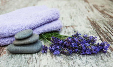 Lavender, massage stones  and towels on a wooden backgroundの写真素材