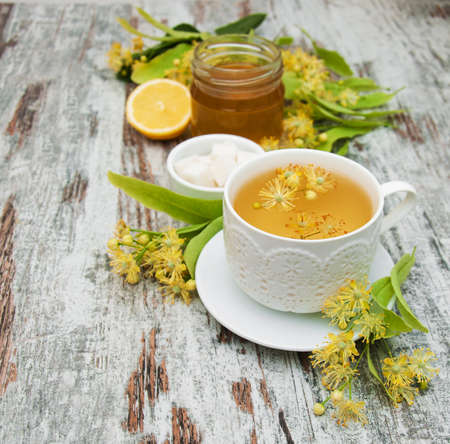 cup of herbal tea with linden flowers on a old wooden backgroundの写真素材