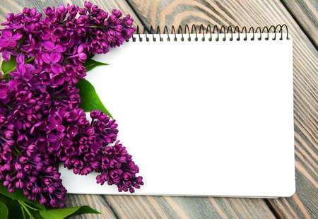 Lilac flowers with empty note on a old wooden backgroundの写真素材