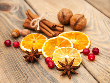 different kinds of spices  and dried oranges on a old wooden backgroundの写真素材
