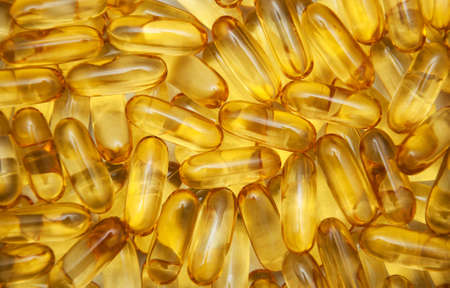 background of yellow translucent pills with the fish oilの写真素材