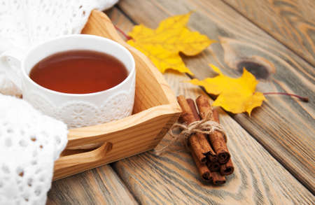 Cup of tea with scarf on a wooden backgroundの写真素材