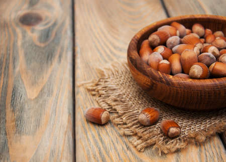 Bowl with hazelnuts on a old wooden backgroundの写真素材