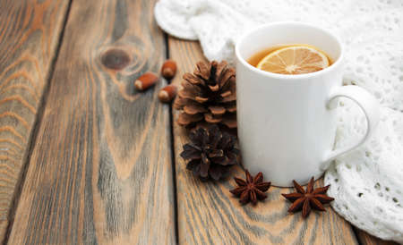 Cup of winter tea with scarf on a wooden backgroundの写真素材