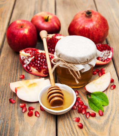 Honey with pomegranate and apples on a old wooden backgroundの写真素材