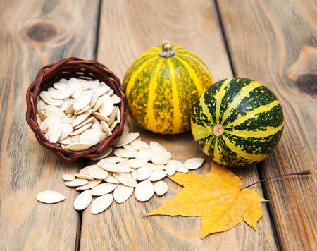 autumn pumpkins with leaves on a wooden backgroundの写真素材