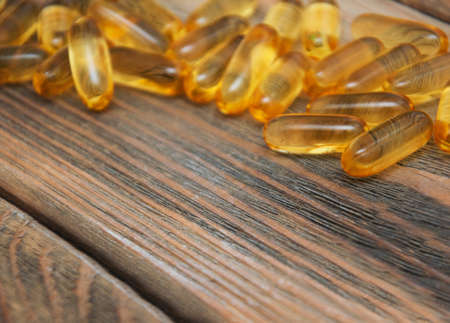 fish oil capsules  on a wooden backgroundの写真素材