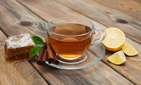 cup of tea with honey and cinnamon on a wooden backgroundの写真素材