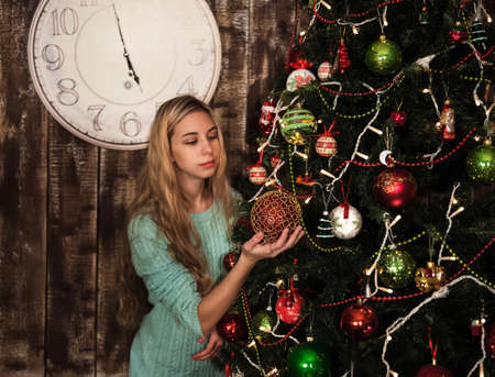 portrait of a pretty girl decorating the christmas treeの写真素材