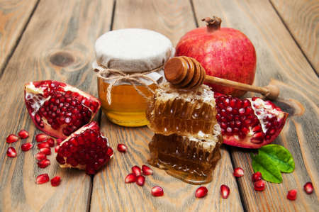 Honey with pomegranate  on a old wooden backgroundの写真素材