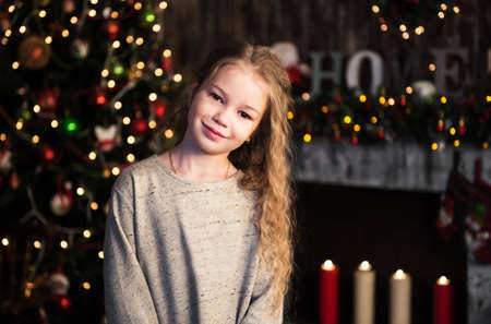 little girl near  christmas tree in homeの写真素材