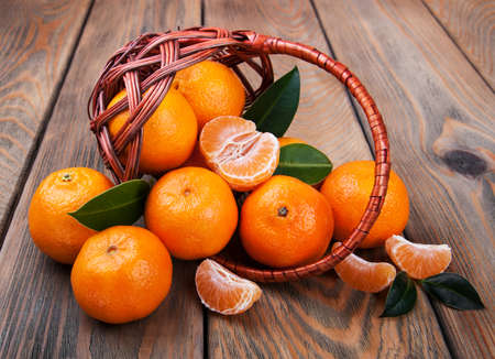 Juicy orange tangerines on a old wooden tableの写真素材