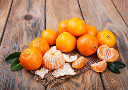 Juicy orange tangerines on a old wooden tableの写真素材