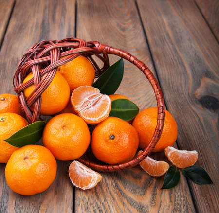 Juicy orange tangerines on a old wooden tableの写真素材