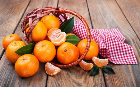 Juicy orange tangerines on a old wooden tableの写真素材