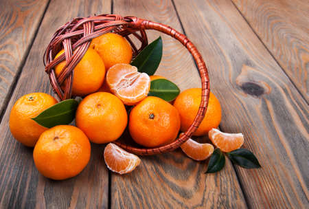 Juicy orange tangerines on a old wooden tableの写真素材